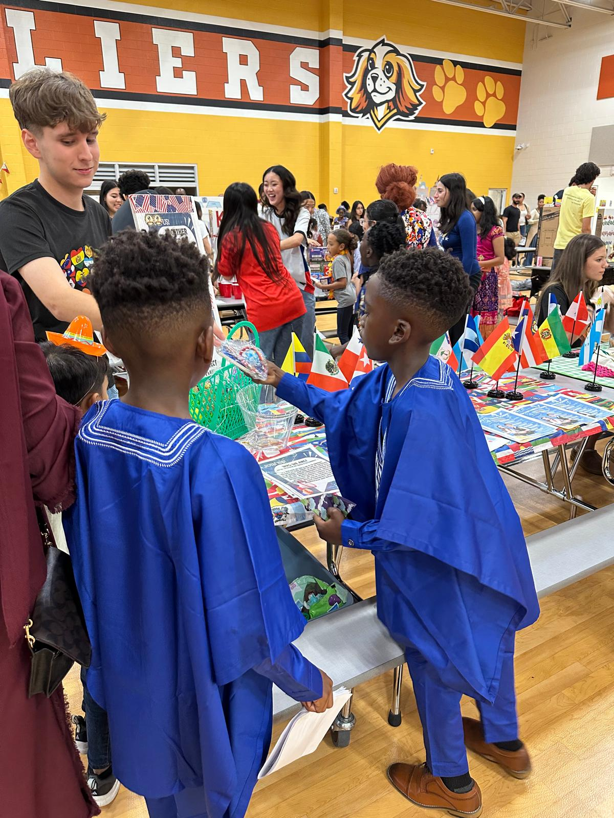 Two children in blue attire looking at materials at the club's community table